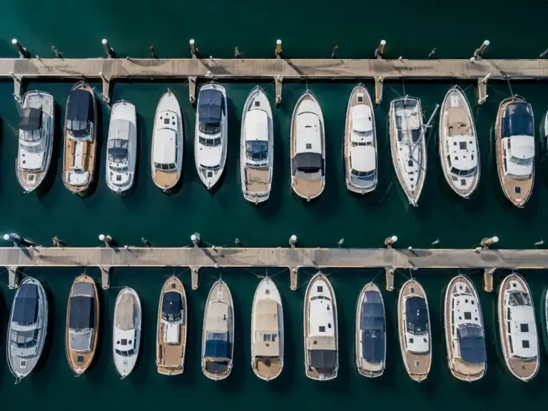Bovenaanzicht van een jachthaven met verschillende motorboten en zeilboten